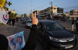 Personas desplazadas regresan a sus casas mientras residentes locales ondean banderas de Hezbollah y una imagen del difunto líder del grupo, Hassan Nasrallah