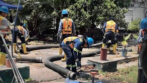 Trabajadores del Siapa realizando trabajos de mantenimiento en tuberías con herramientas y plantas alrededor