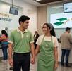 Una pareja de jóvenes con uniformes de color verde en una sucursal de Financiera para el Bienestar
