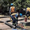 Trabajadores del Siapa realizando trabajos de mantenimiento en tuberías con herramientas y plantas alrededor