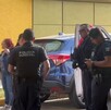 Tres policías de Guadalajara hablando con una mujer con un paramédico de la Cruz Roja a un lado, dos mujeres al fondo y dos camionetas alrededor