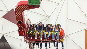 Personas disfrutan de los juegos mecánicos en la Feria de Puebla 2026.