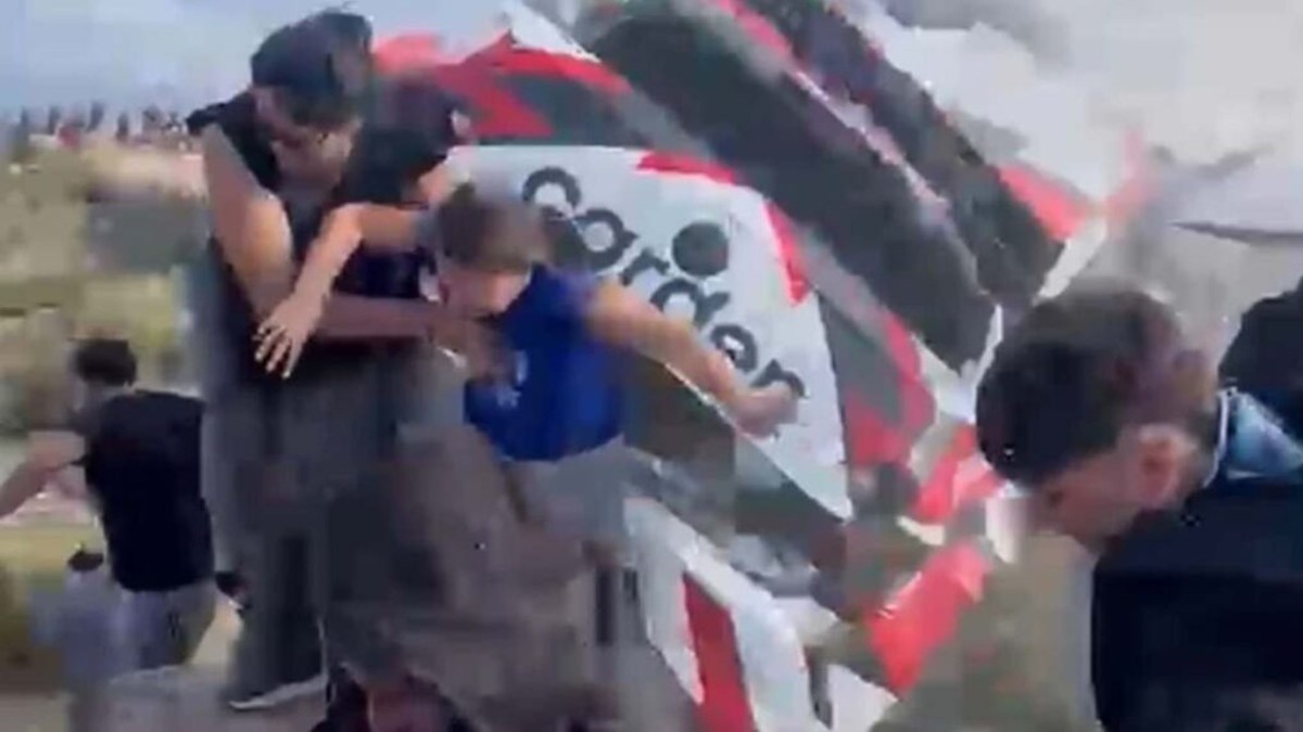 Auto deportivo participante del Rally Sudamericano en Argentina volcando al lado de una mujer y una niña con hombre huyendo alrededor