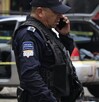 Policía hablando por teléfono junto a un vehículo asegurado.