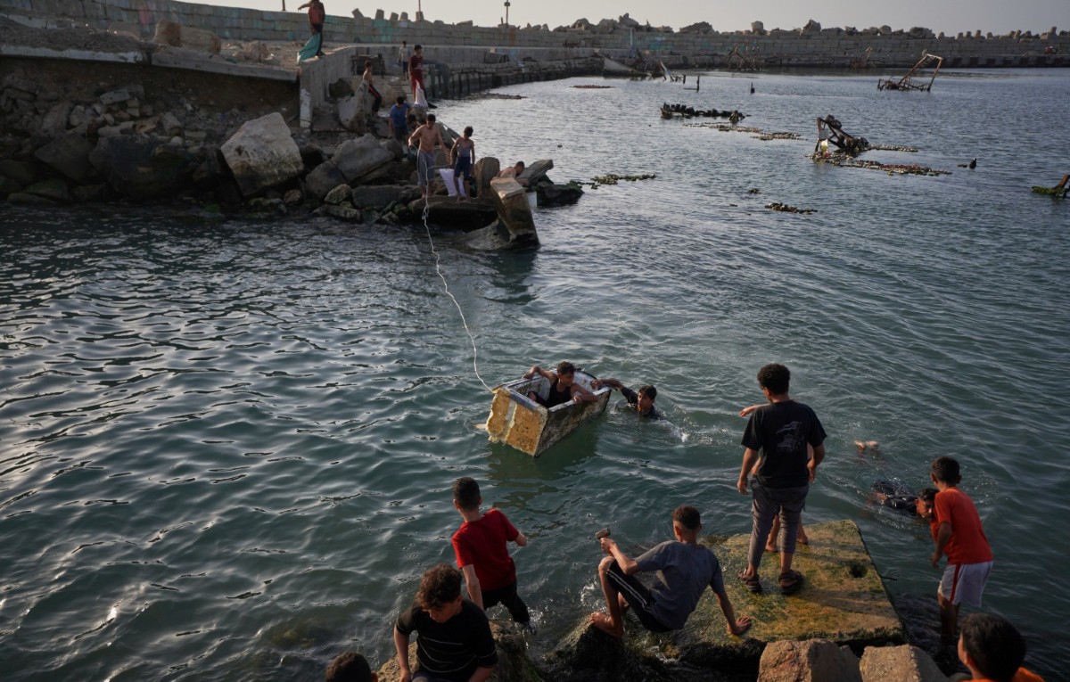 Jóvenes palestinos juegan y nadan en una cuenca portuaria en Ciudad de Gaza, el 19 de abril de 2026.