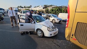 Automóvil Chevy color blanco destrozado de la parte frontal tras chocar contra camión turístico con paramédicos, policías viales y vehículos alrededor