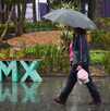 Una mujer se protege de las constantes precipitaciones registradas esta tarde en la capital.