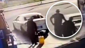 Coche blanco surtiéndose de gasolina.