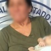 Mujer de la tercera edad cargando a un bebé rescatado.
