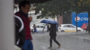 Una mujer se protege de las constantes precipitaciones registradas en la capital mexicana.