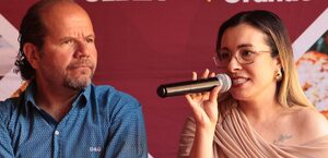 Una mujer y un hombre comparten micrófono.