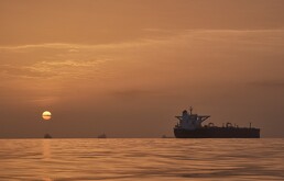 El sol sale tras varios petroleros fondeados en el estrecho de Ormuz en la costa de la isla de Queshm, Irán, el sábado 18 de abril de 2026.