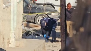 Peritos del Instituto Jalisciense de Ciencias Forenses realizando el levantamiento de un cuerpo cubierto por una bolsa negra