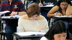 Se observa a unos estudiantes con cuadernos, lapices y están viendo unos papeles.