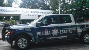 Patrulla de policía estacionada afuera del Centro Escolar Niños Héroes de Chapultepec, en Puebla.