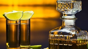 Botella y shots de tequila con sal y limón