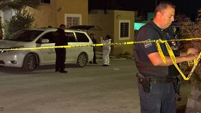 Se observa a un hombre con uniforme de policía y una cinta amarilla de precaución.