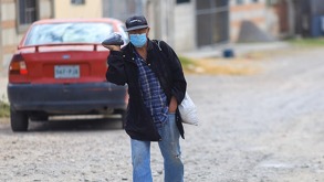 Hombre de la tercera edad atravesando un camino de tierra.