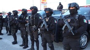 Se observa a varias personas con la cara tapada, con uniforme de policías, sólo se les ven los ojos.