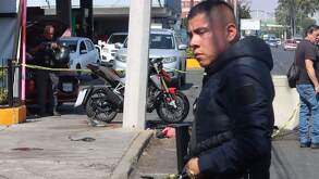 Hombre caminando en Ecatepec junto a lugar acordonado por la policía