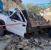 Camioneta blanca cargada con bloques de concreto estrellada contra una barda y acordonada por cinta policiaca con un bombero de Tlaquepaque detrás