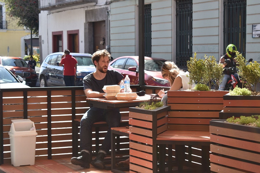 Personas comiendo en una mesa al aire libre.