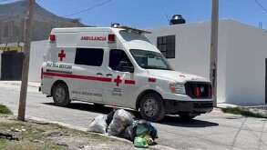 Se observa a una ambulancia color blanco con rojo estacionada, está sobre una calle.