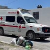 Se observa a una ambulancia color blanco con rojo estacionada, está sobre una calle.