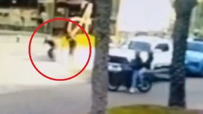 Imagen de hombres en motocicleta disparando hacia dos personas en la banqueta.