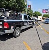 Estacionamiento de Plaza Revolución con autos, moto de policía y una patrulla sosteniendo una cinta policiaca que acordona la escena