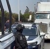 Patrulla y policías junto a un tráiler estacionado en la carretera.