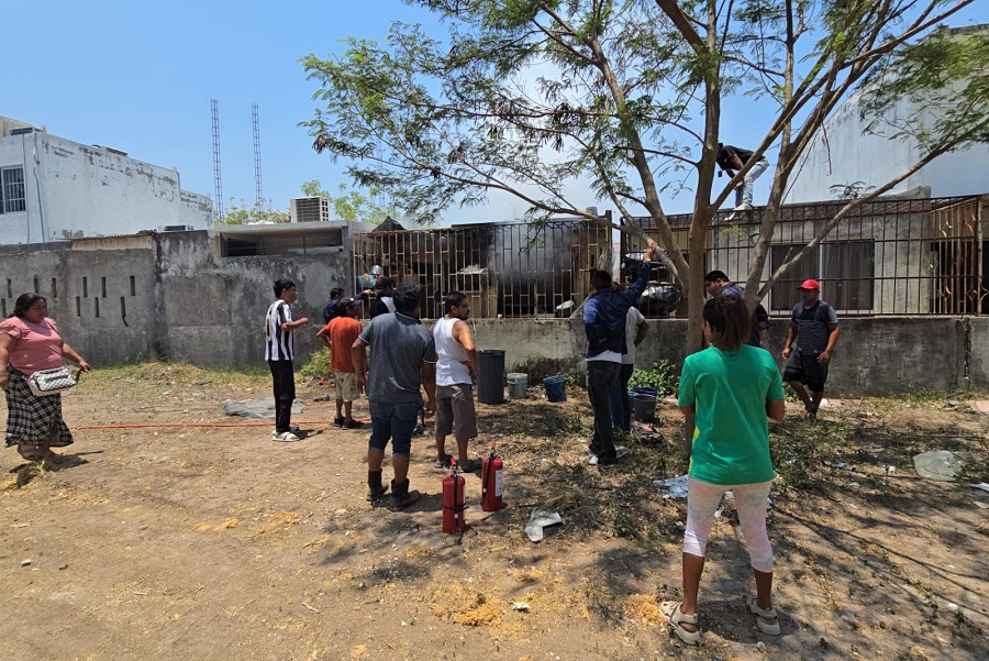 Personas afuera de una vivienda incendiada en Veracruz.