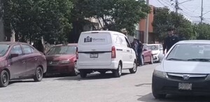 Se observa una camioneta blanca que dice Funerarias Martínez; está estacionada en medio de la vía pública.