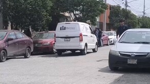 Se observa una camioneta blanca que dice Funerarias Martínez; está estacionada en medio de la vía pública.
