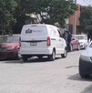 Se observa una camioneta blanca que dice Funerarias Martínez; está estacionada en medio de la vía pública.
