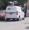 Se observa una camioneta blanca que dice Funerarias Martínez; está estacionada en medio de la vía pública.
