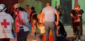 Se observa a varias personas y niños en medio de la calle, hay un señor tendido en el suelo.