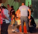 Se observa a varias personas y niños en medio de la calle, hay un señor tendido en el suelo.