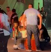 Se observa a varias personas y niños en medio de la calle, hay un señor tendido en el suelo.