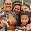 Mujeres cargando a sus perros chihuahuas en un evento