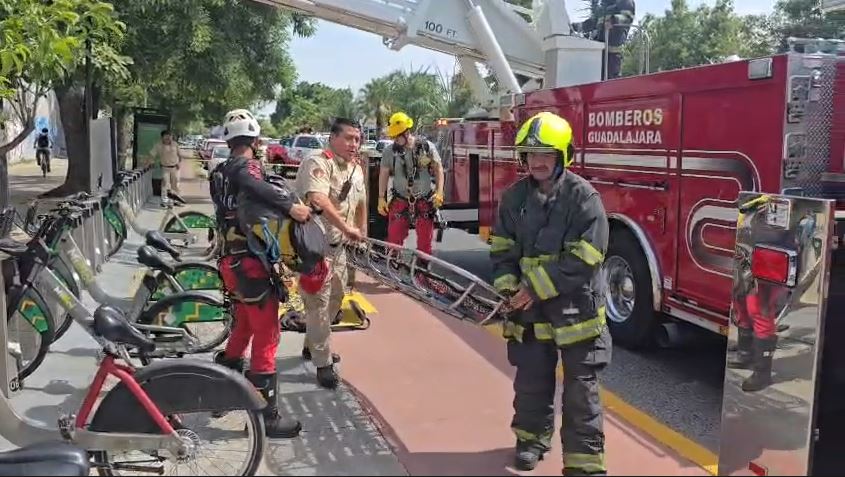 Paramédicos y elementos de Protección Civil transportando una camilla al lado de un camión de Bomberos de Guadalajara con estación de Mi Bici a un costado