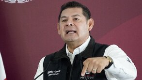 Hombre señala hacia abajo mientras habla.