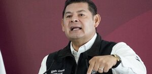 Hombre señala hacia abajo mientras habla.