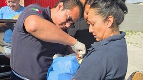 Se observa a un bebé recién nacido, a unos policías y una mujer cargando al bebé.