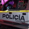 Vista lateral de una patrulla de la Policía Municipal de Tlaquepaque detrás de una cinta policiaca amarilla