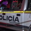 Vista lateral de una patrulla de la Policía Municipal de Tlaquepaque detrás de una cinta policiaca amarilla