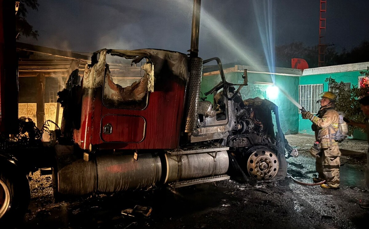 Elementos de bomberos apagando el fuego de un tráiler que se incendió en el ejido San Luis.