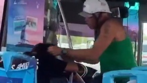 Hombre de playera verde y casco golpea a una mujer en el transporte público.