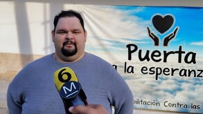Hombre con playera azul con micrófono amarillo