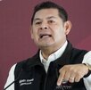 Hombre señala hacia abajo mientras habla.